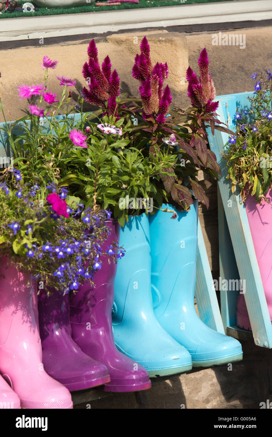 Regno Unito, Inghilterra, Yorkshire, Calderdale, Hebden Bridge, Barker's Terrace, B Perle shop, colurful Stivali in gomma utilizzato come piano di fiori Foto Stock