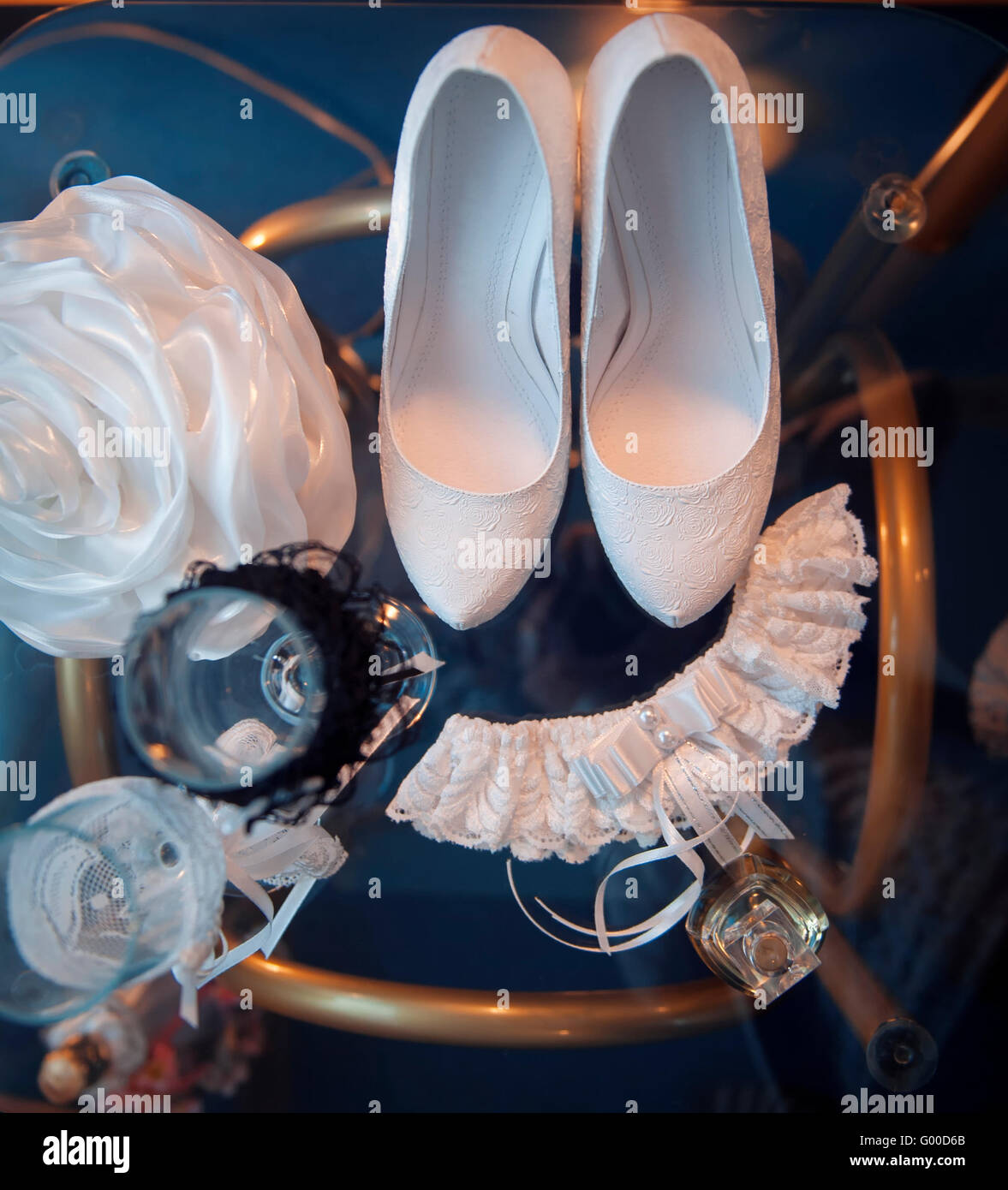 Bianco scarpe nuziale e altri attributi di nozze su un tavolo Foto Stock