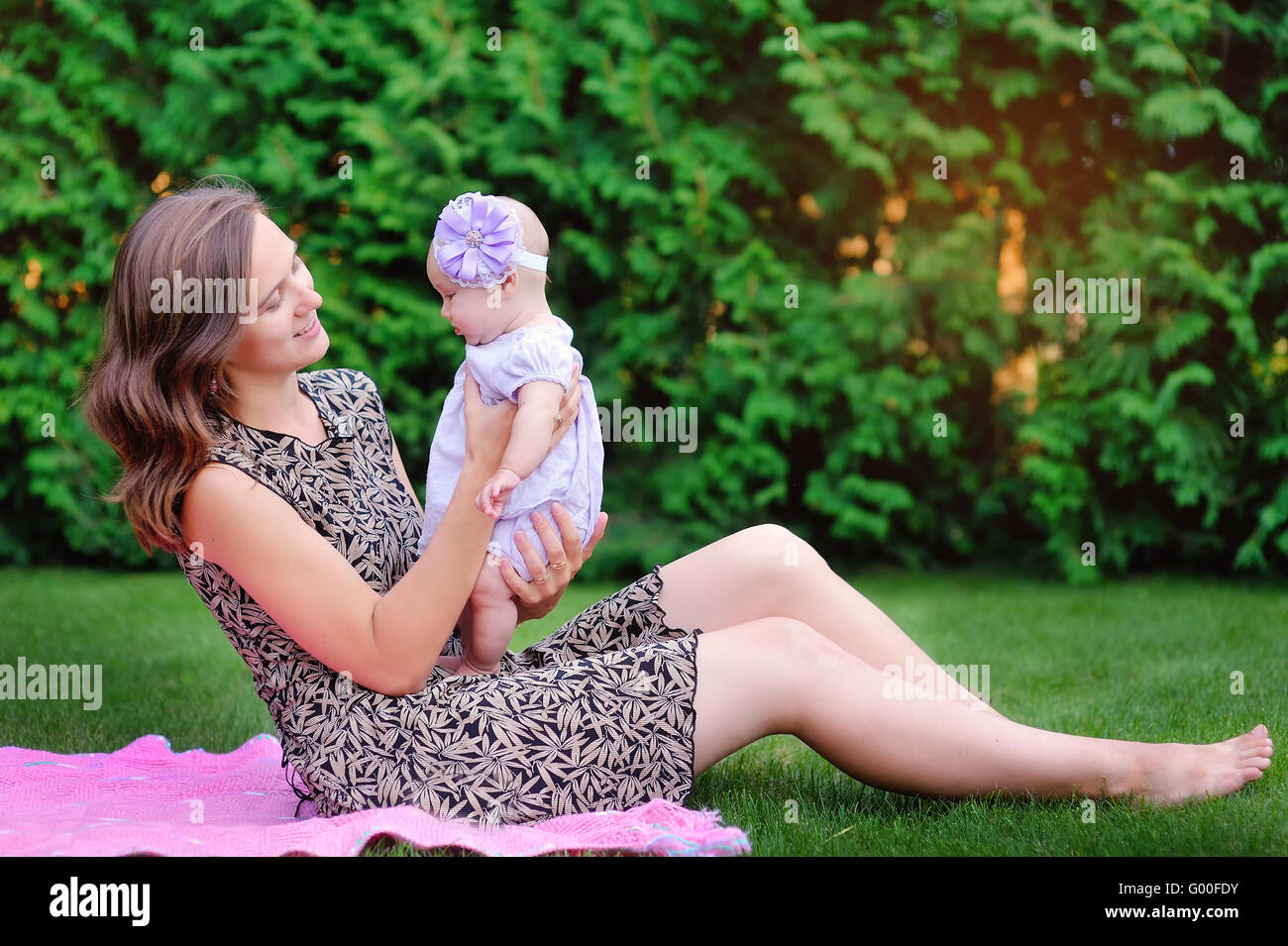 La mamma tiene sulle mani di una piccola figlia all'aperto nel parco Foto Stock