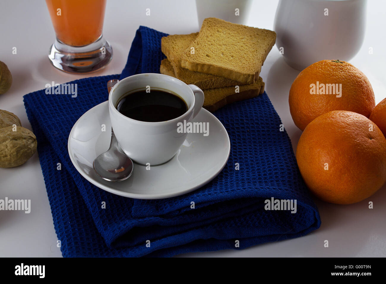 Una tazza di caffè nero con naturale arance biologiche come la colazione, su sfondo bianco Foto Stock