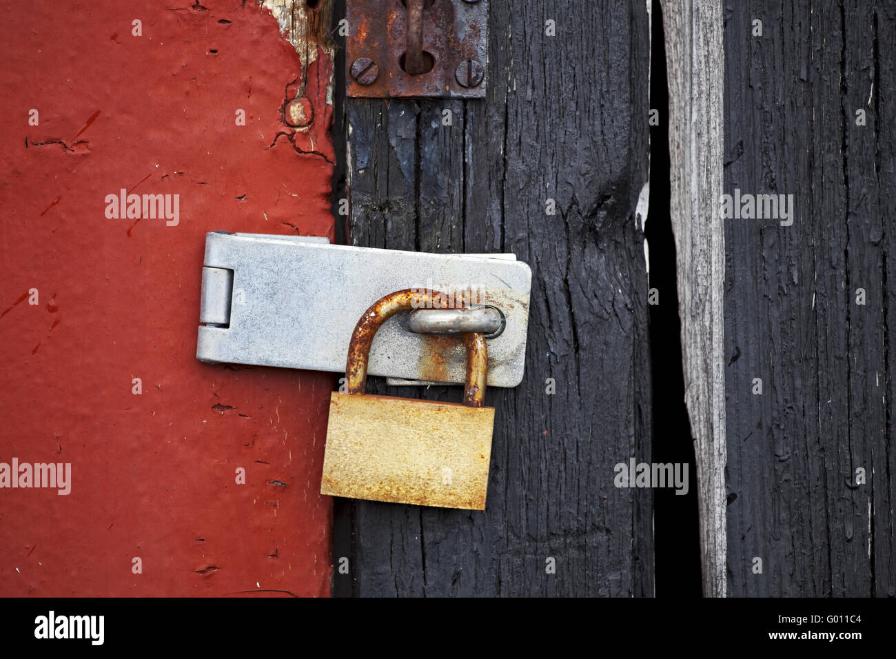 Vecchio arrugginito lucchetto sulla porta di legno Foto Stock