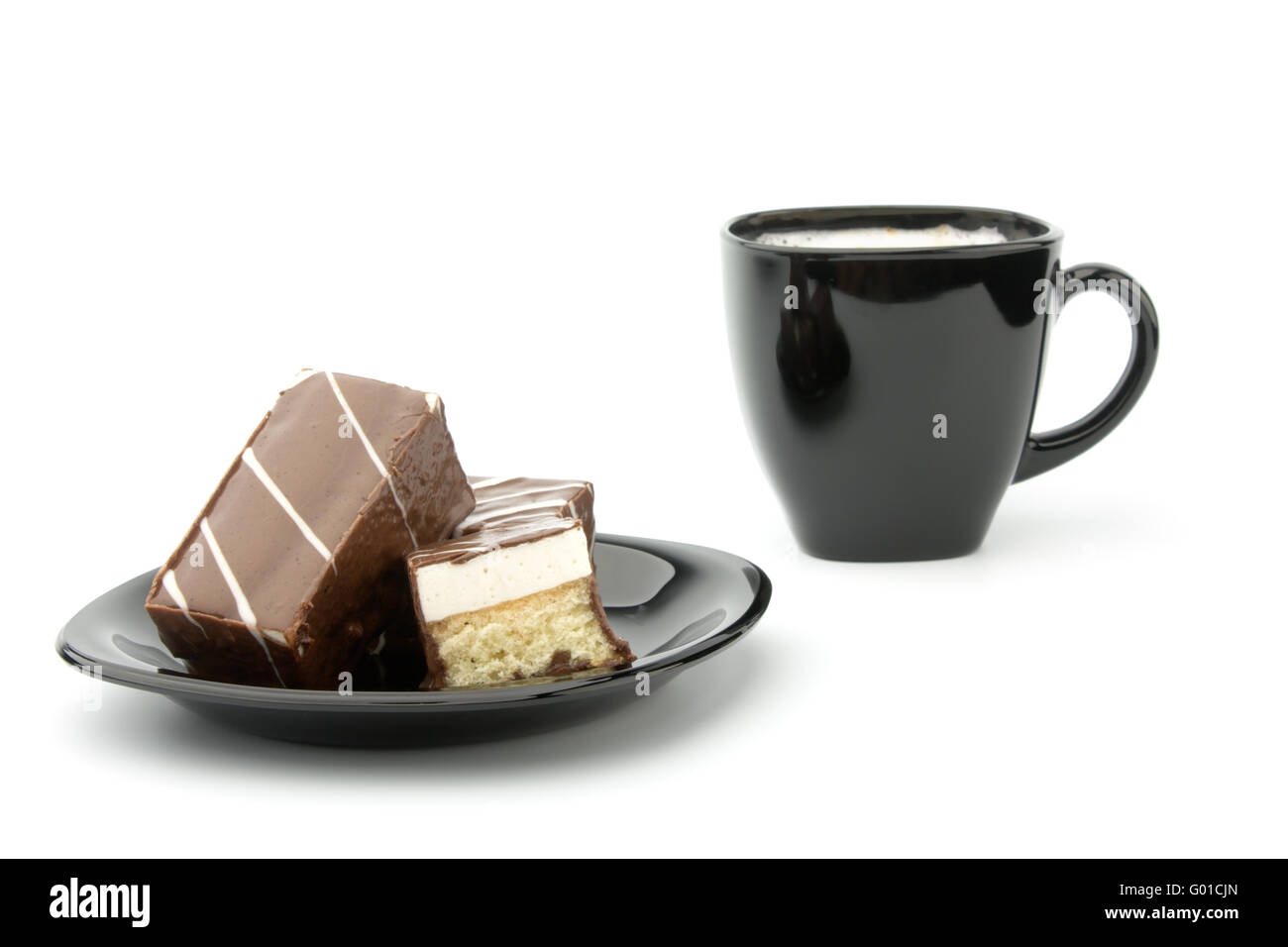 Tre cookie in cioccolato sulla piastra nera e la tazza di caffè isolato su bianco Foto Stock