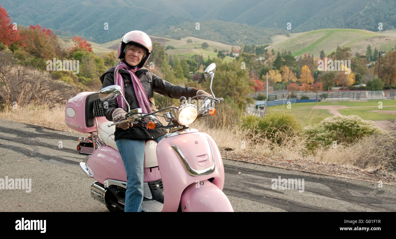 Sessanta anni di crociera biker giù una collina Foto Stock