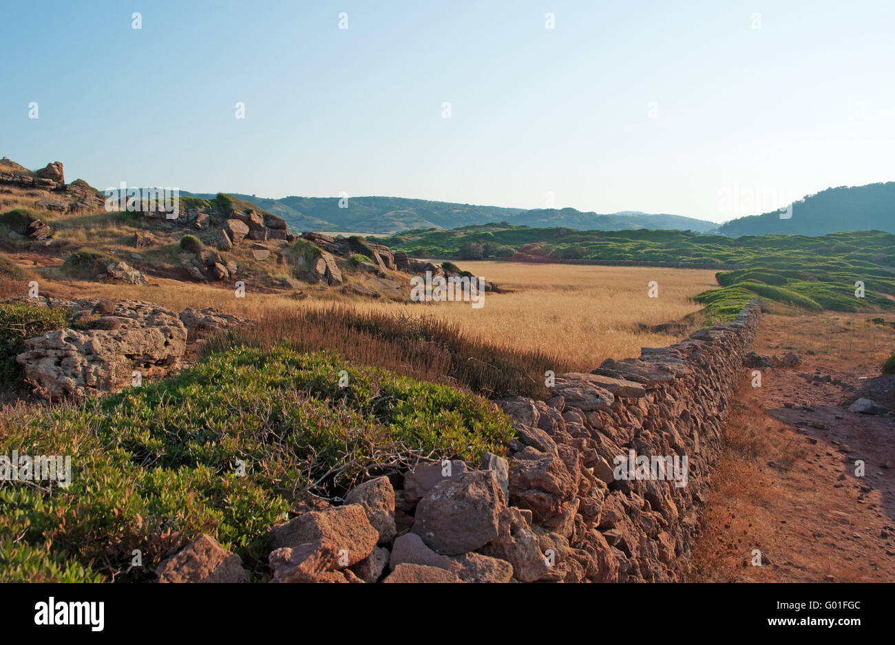 Menorca: sabbia rossa sul sentiero per Cala Pregonda, isolata insenatura di scogli e sabbia rossa: la sua spiaggia sembra come il pianeta di Marte Foto Stock