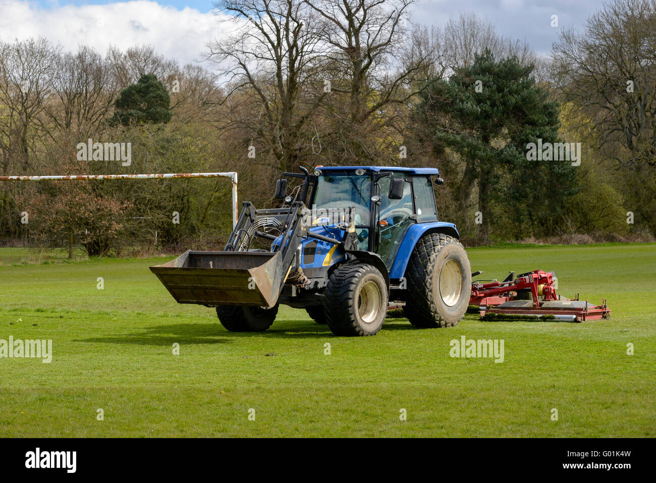 Il trattore falciare l'erba su un campo di calcio in un parco pubblico in Inghilterra. Foto Stock