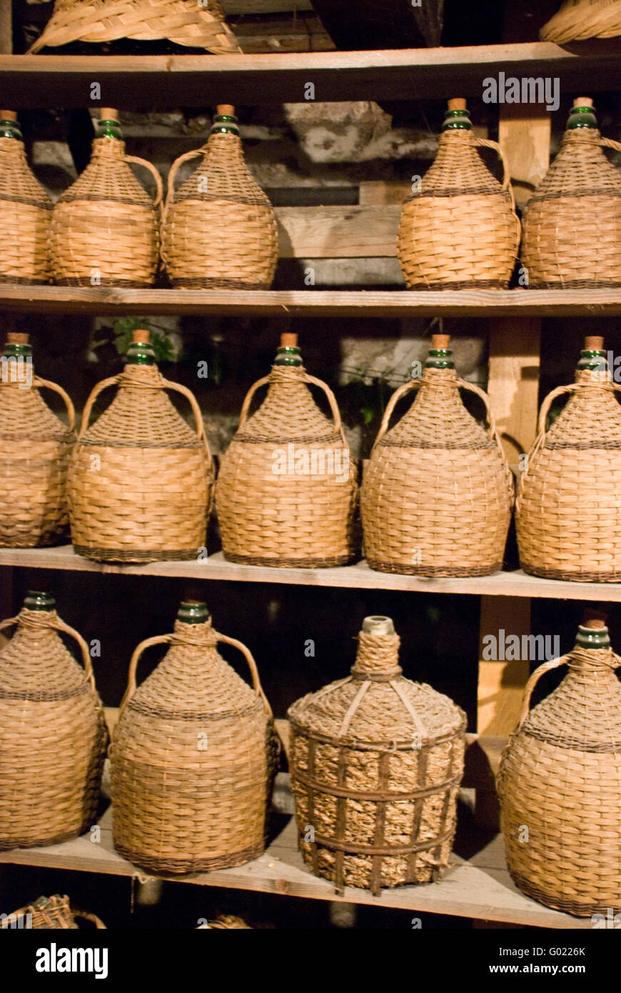 Vino buttles impilati nella vecchia cantina dell'azienda vitivinicola Foto Stock