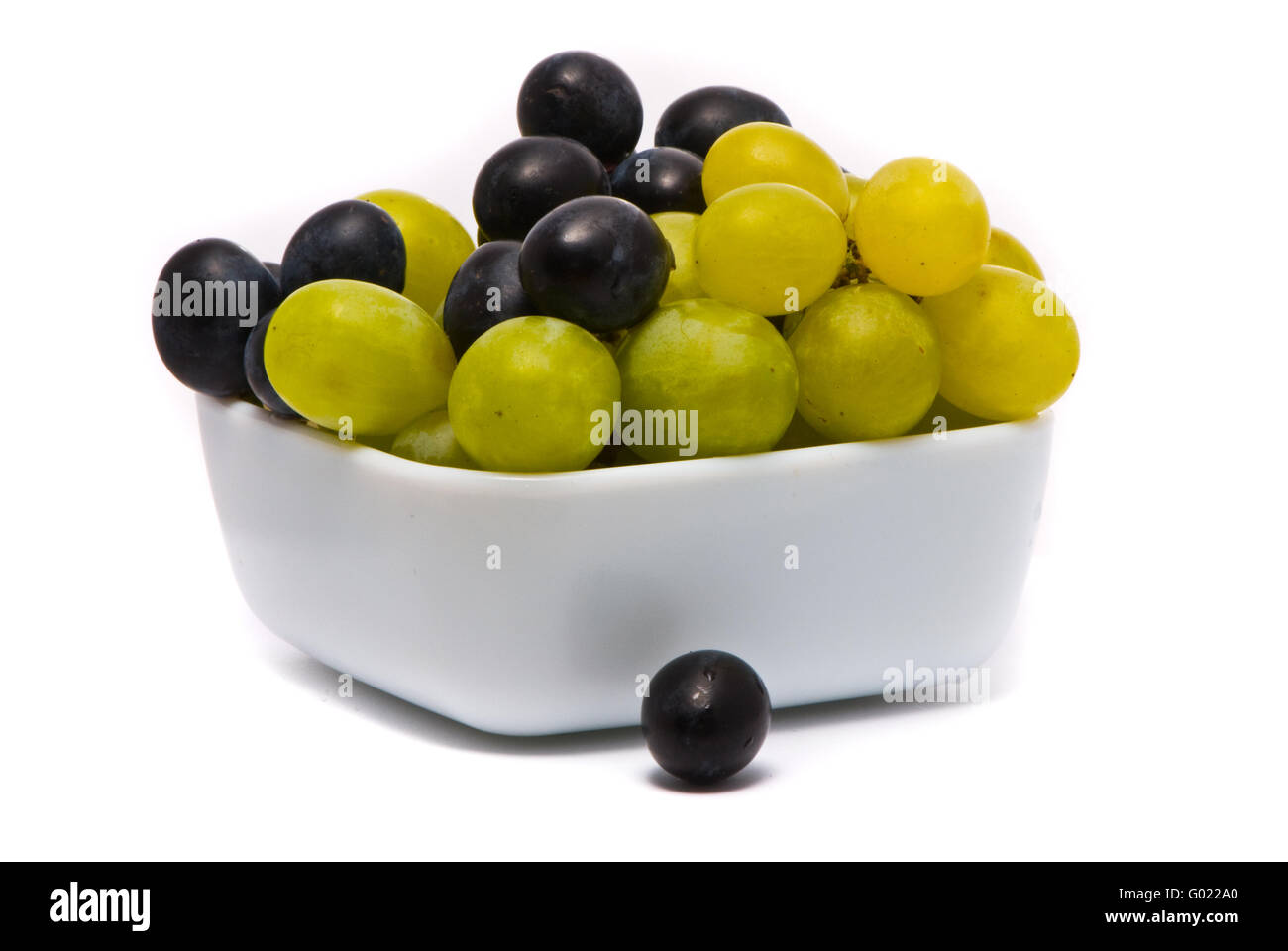 Il verde e il blu uva su uno studio sullo sfondo bianco Foto Stock