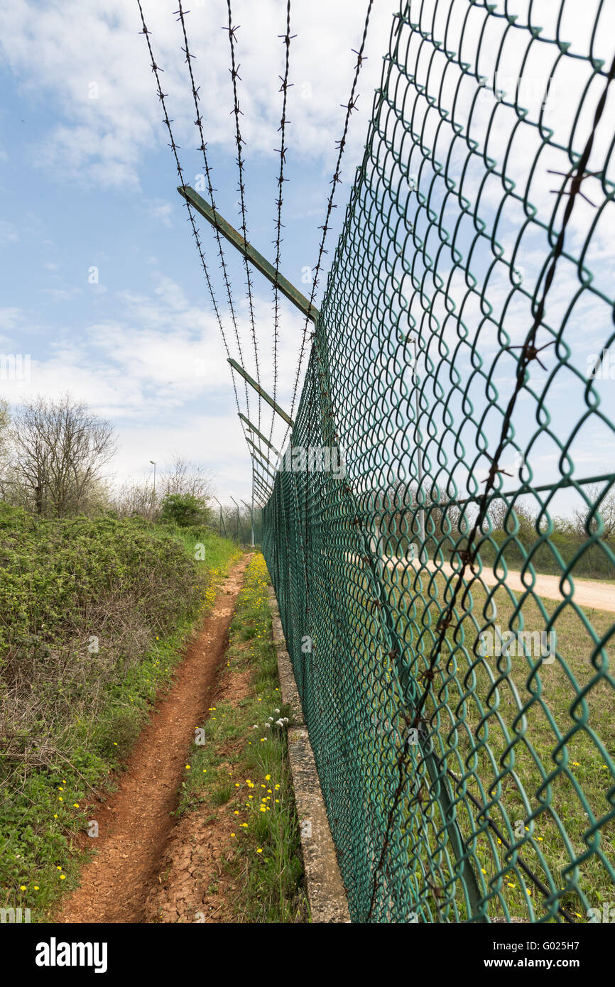 Maglia Verde recinto e rabboccato con filo spinato. Foto Stock