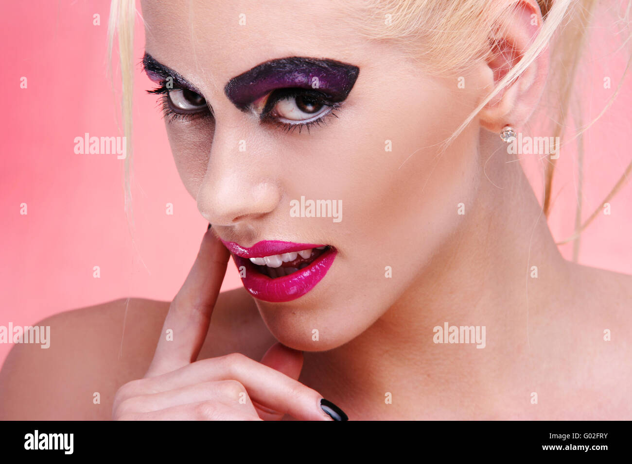 Giovane donna in rosa ritratto. viola per il make-up e Grosse labbra biondi capelli funky style Foto Stock