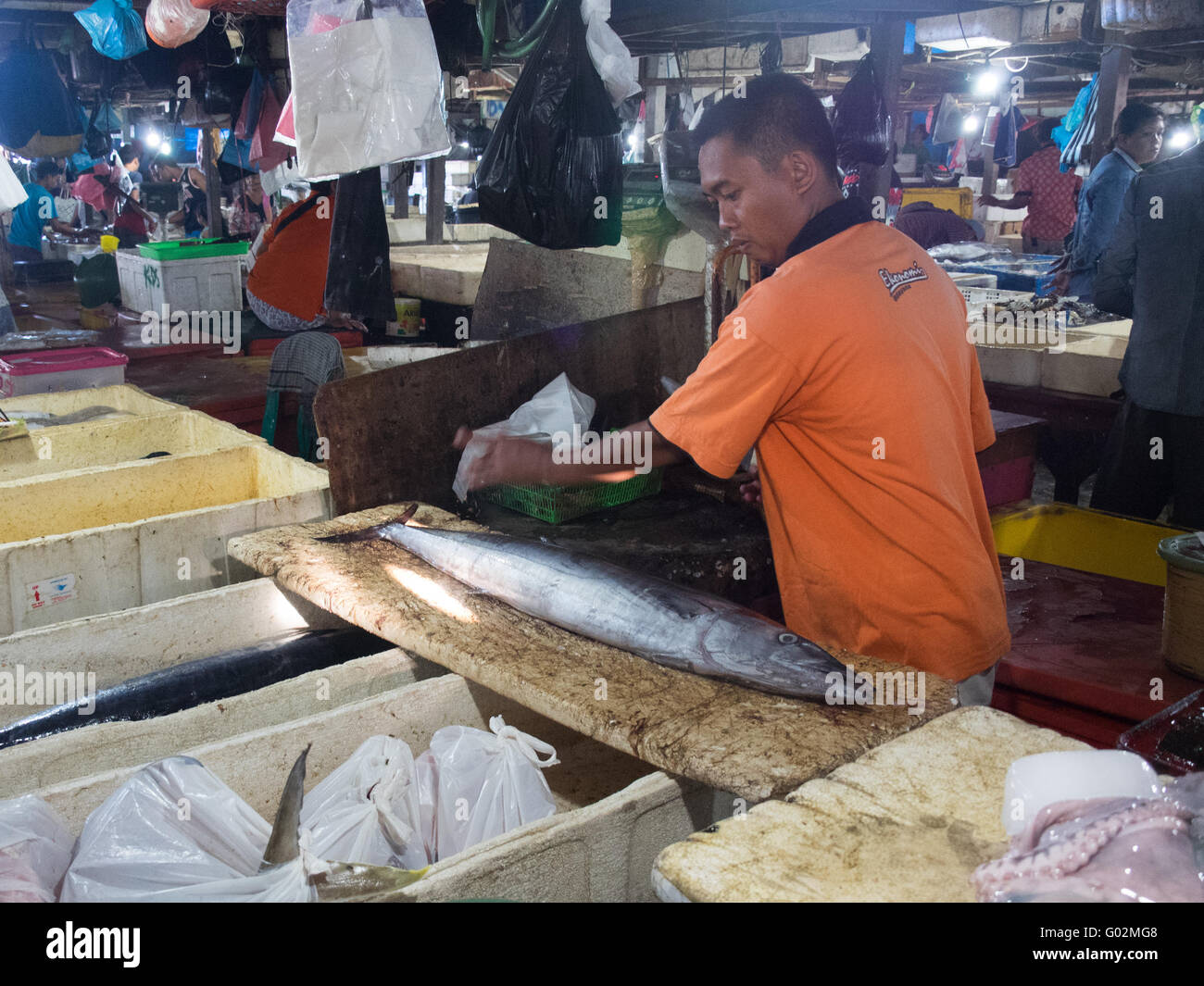 Pescivendolo preparazione in scala di un pesce a Jimbaran mercati di pesce. Foto Stock