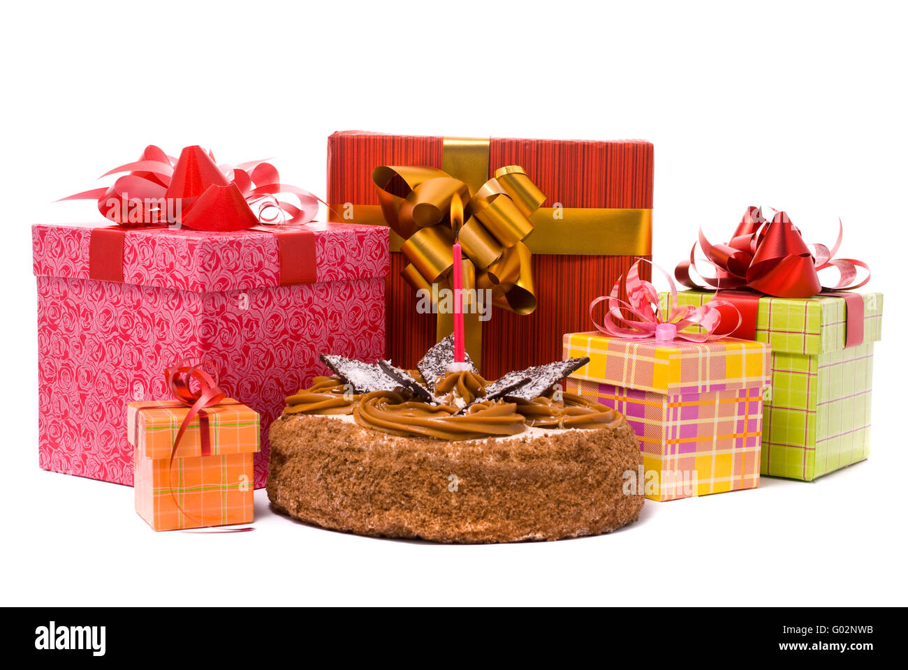 Torta con le candele e i doni in scatole su sfondo bianco Foto Stock