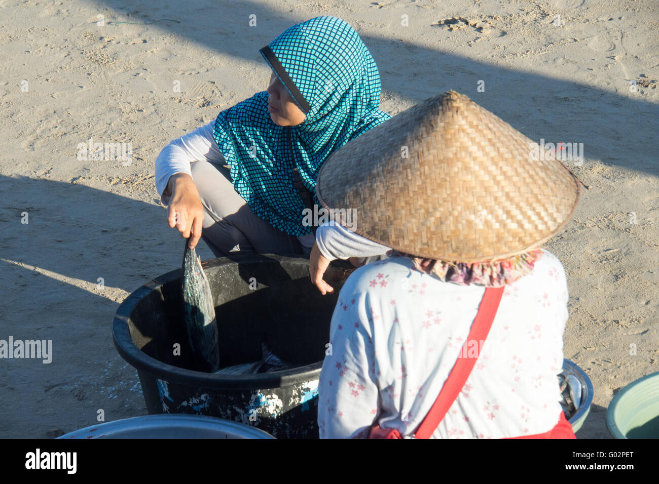 Una donna di vendita del pesce sulla spiaggia di Jimbaran, Bali. Foto Stock