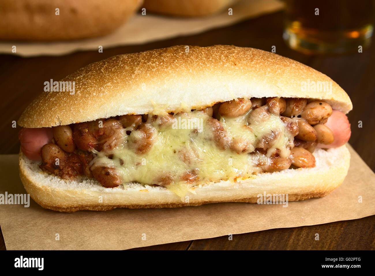 Cotta cheesy chili hot dog, fotografati con luce naturale (messa a fuoco selettiva, messa a fuoco sulla parte anteriore del peperoncino hot dog) Foto Stock