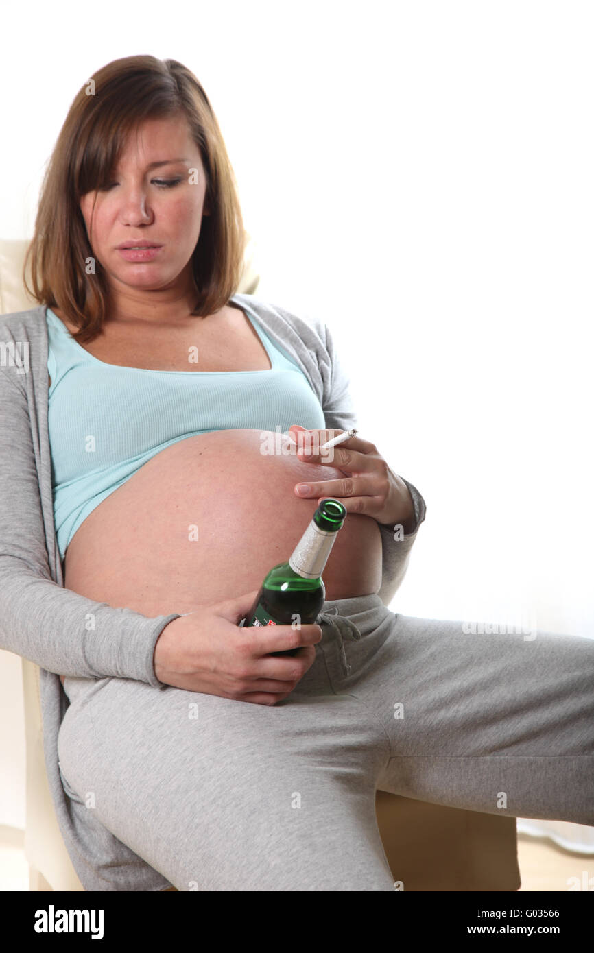 Donna incinta fuma una sigaretta e bere alcoho Foto Stock