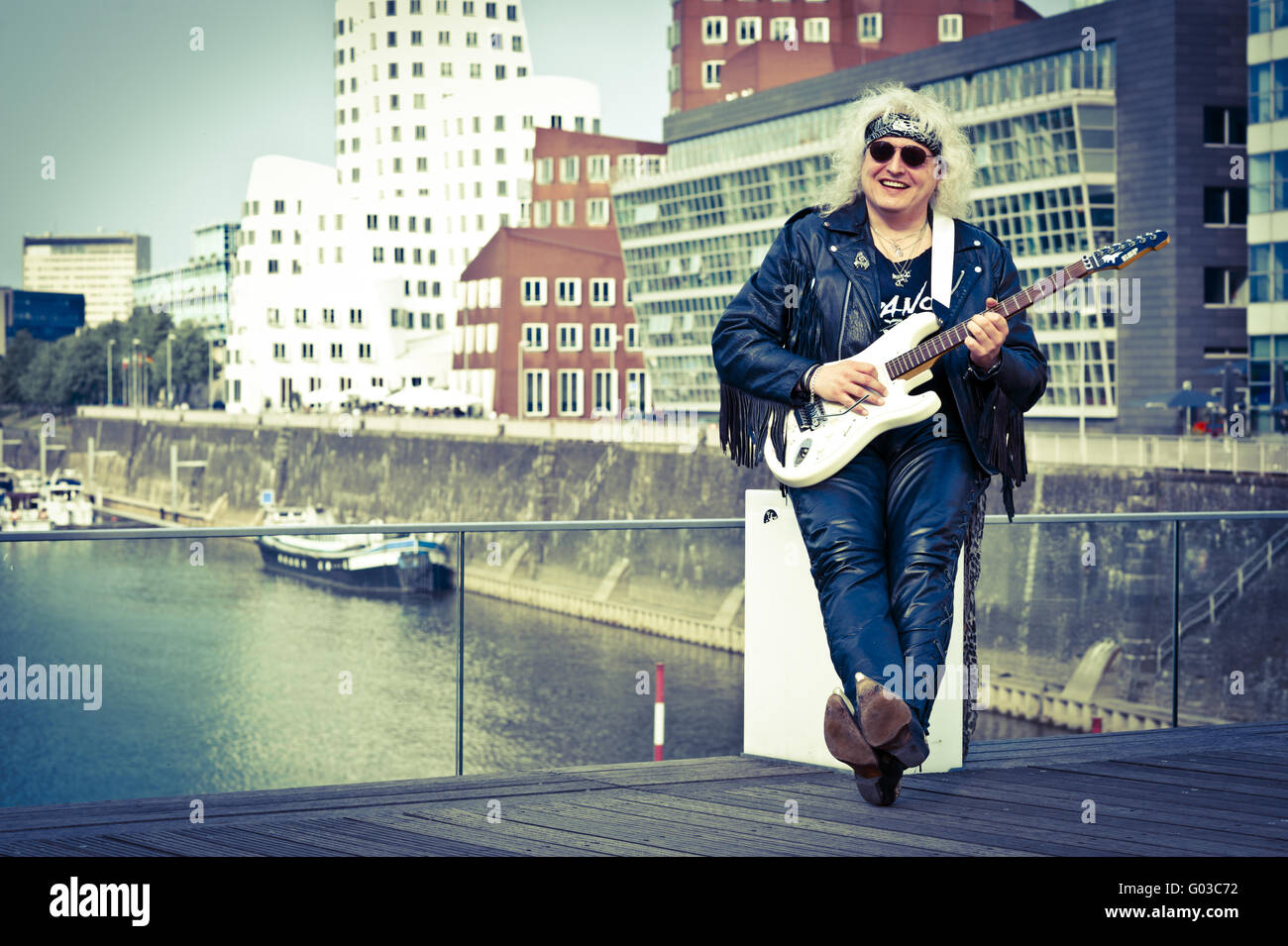 Musicista rock con una chitarra in Media Harbour D Foto Stock