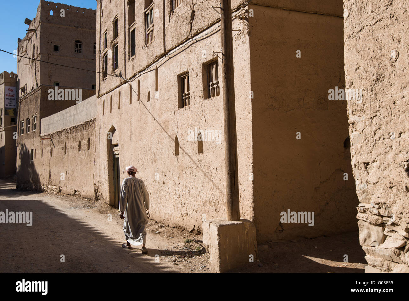 Uomo che cammina in abbandonato Al Hamra Village, Oman. Foto Stock