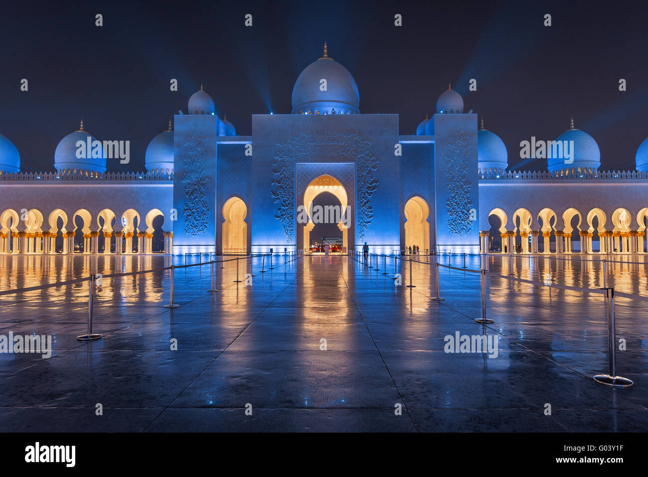 Sheikh Zayed grande moschea di notte coperto con belle luci blu e raggi di luce Foto Stock