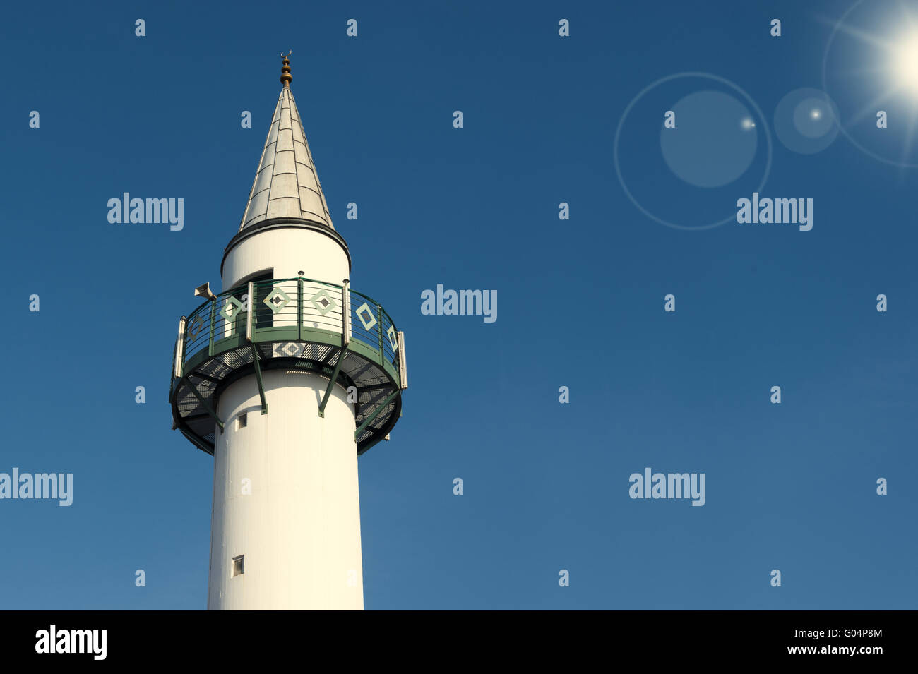 Il minareto di fronte cielo blu sotto il sole Foto Stock