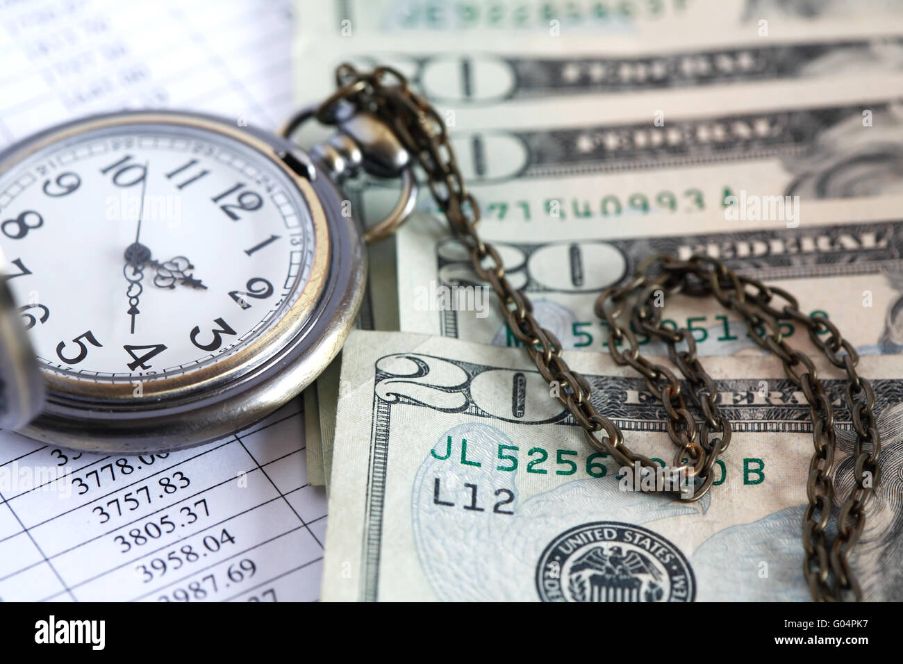 Il tempo è denaro. Vista dettagliata del dollaro banconote nei pressi di aprire pocket watch sulla carta elenco con cifre Foto Stock