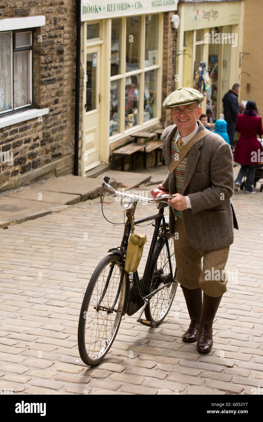 Regno Unito, Inghilterra, Yorkshire, Haworth 40s Weekend, Main Street, Adrian Worral, da St Annes spingendo la sua bicicletta fino alla collina. Foto Stock