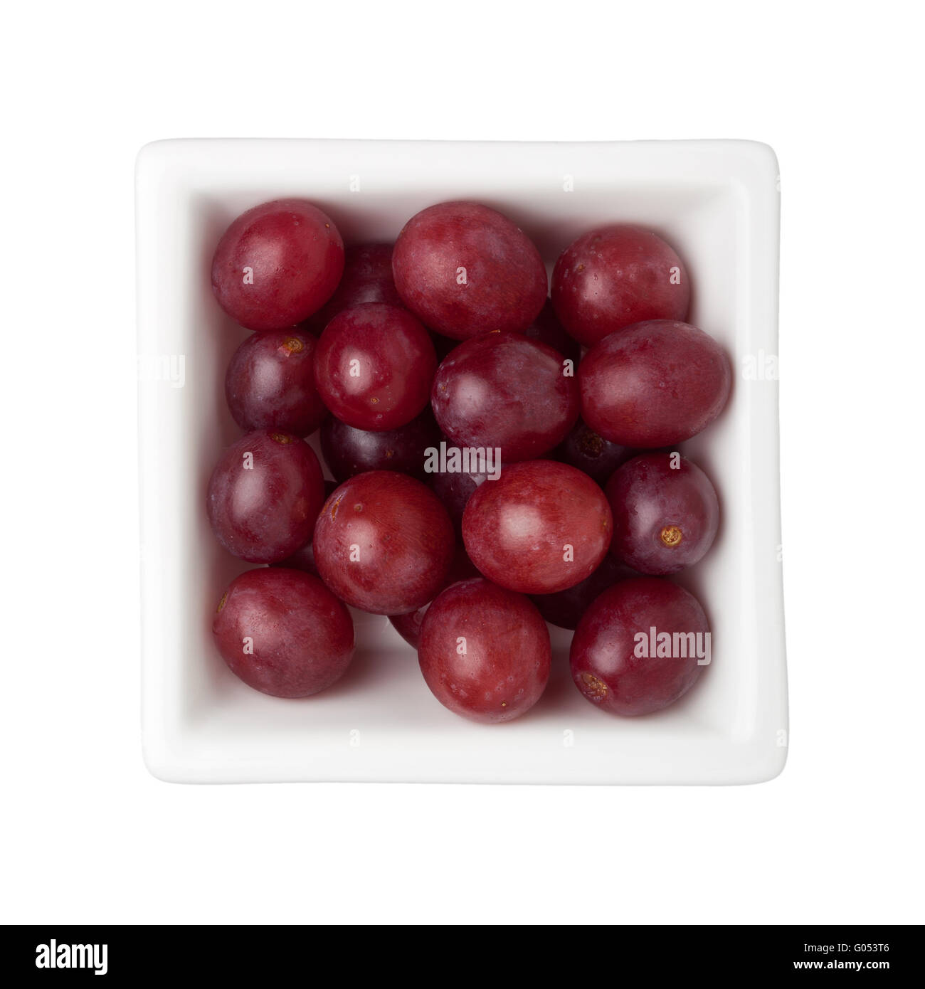 Le uve rosse in un recipiente quadrato isolato su sfondo bianco Foto Stock