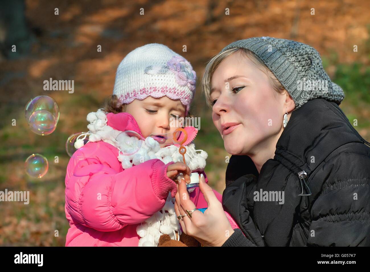 Madre e figlia a soffiare bolle nel parco Foto Stock