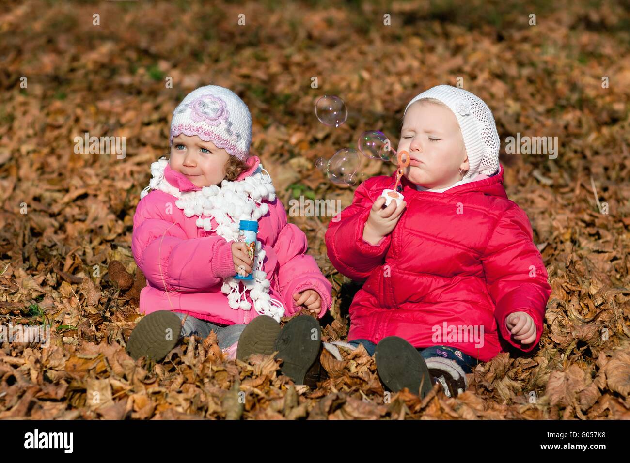 Due bambine a soffiare bolle nel parco Foto Stock