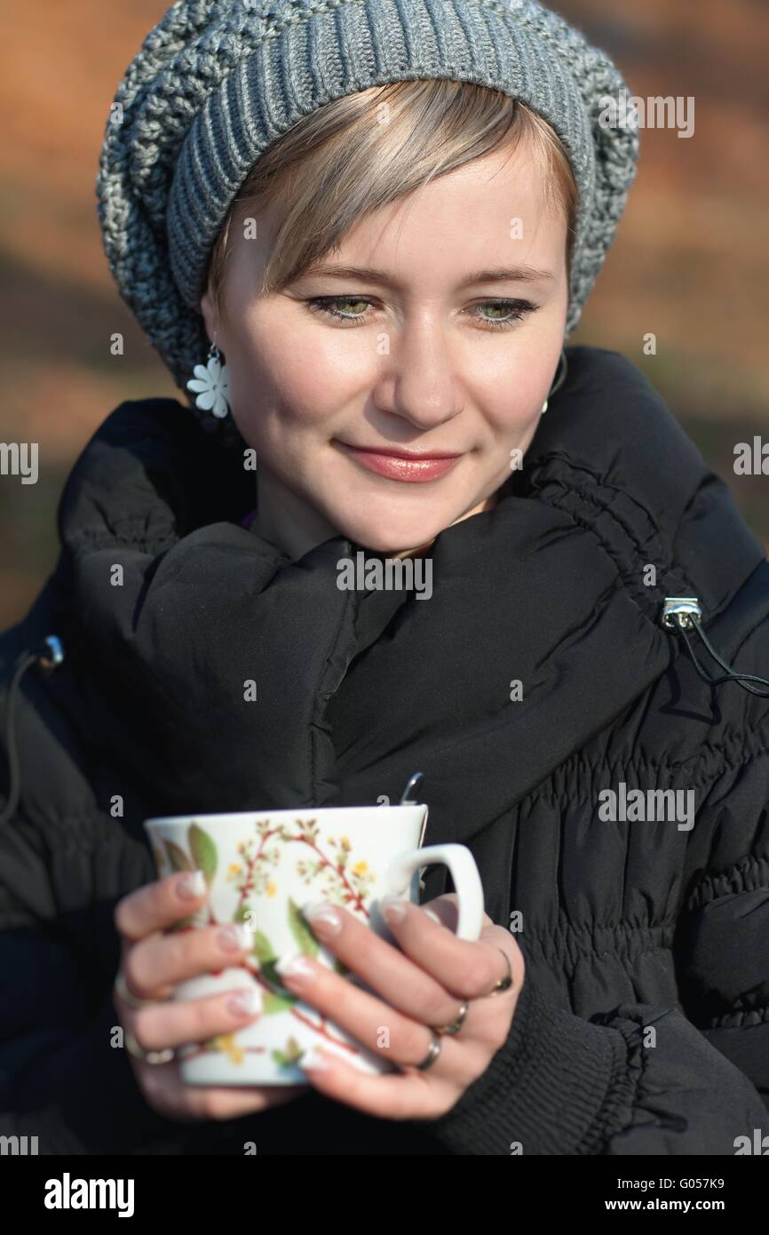 Donna attraente di bere il caffè nella foresta di autunno Foto Stock