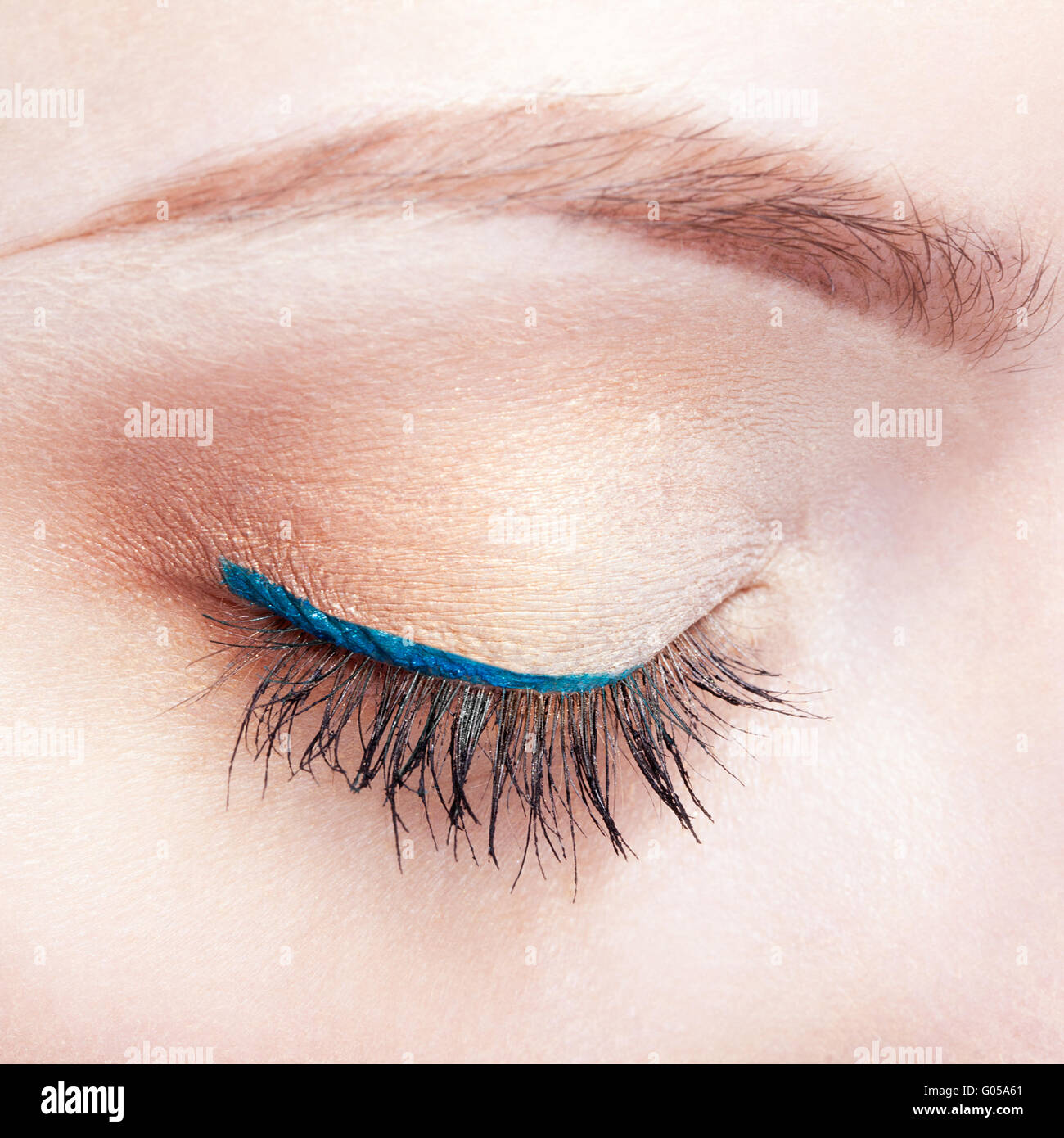 Closeup colpo di donna chiuso occhio e sopracciglia con il giorno trucco e freccia blu Foto Stock