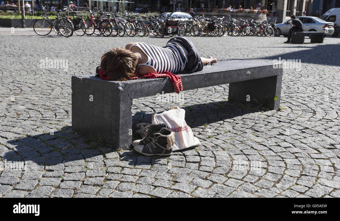 Giovane donna che dorme sul duro banco di pietra nel ci Foto Stock