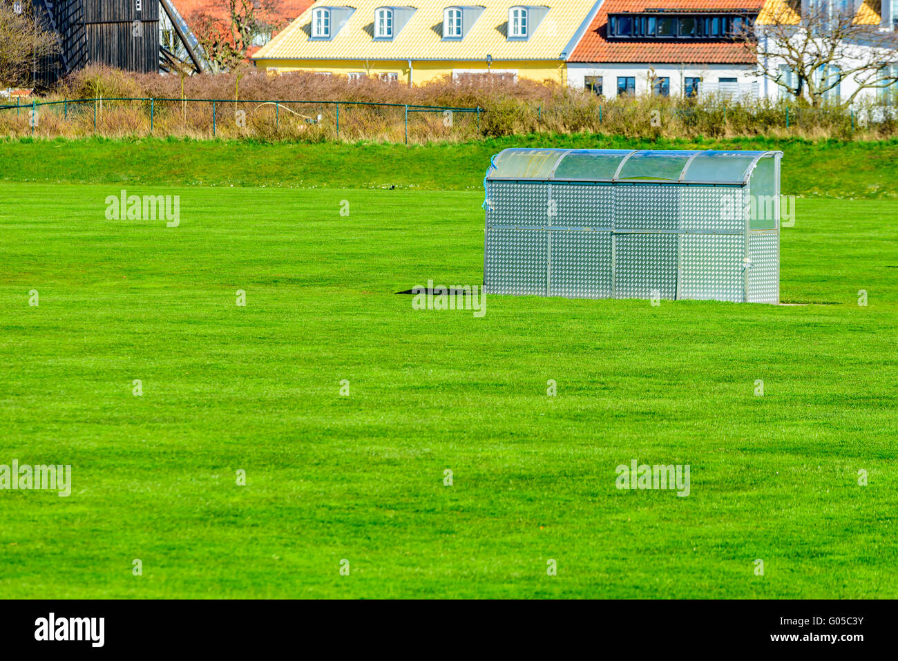 Un rifugio in alluminio su un campo di calcio o sports arena. Di recente il taglio erba verde tutto intorno. Foto Stock