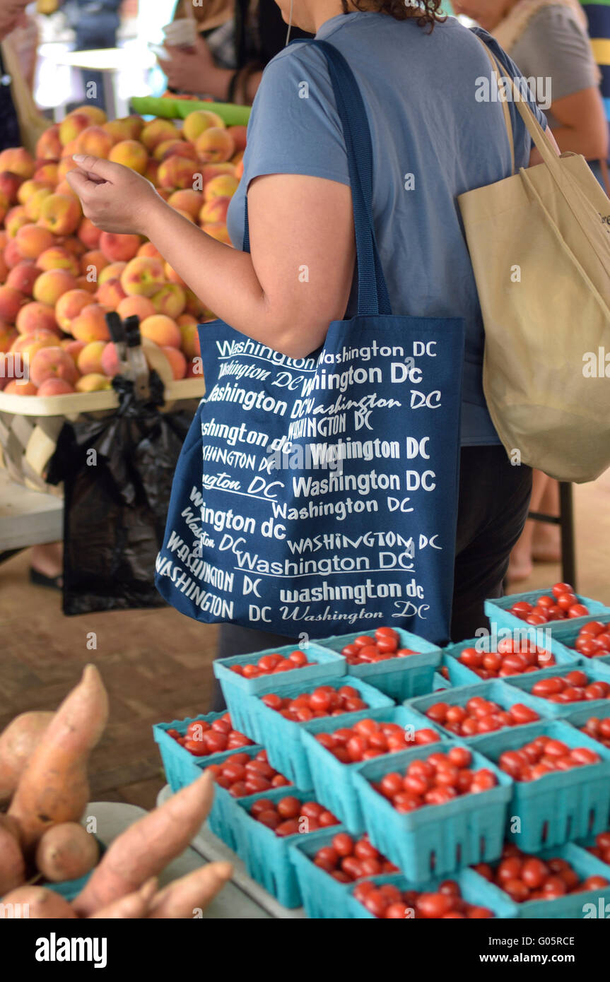 Una donna lo shopping al mercato degli agricoltori al mercato orientale. DC più antica azionata continuamente cibo fresco il mercato pubblico. Washington DC, Stati Uniti d'America Foto Stock