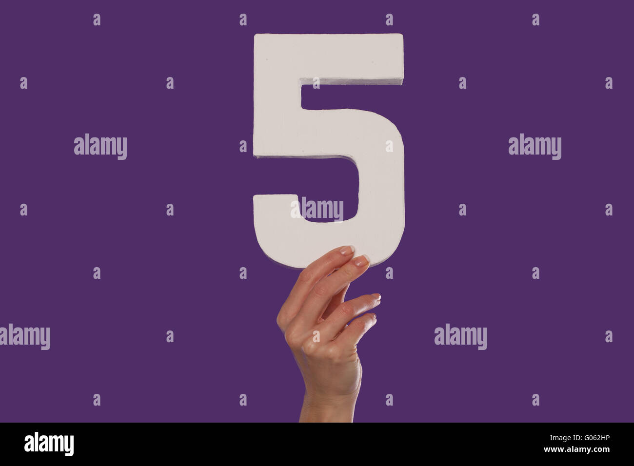 Femmina lato tenendo alto il numero 5 dal botto Foto Stock