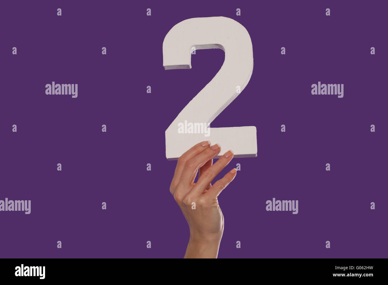 Femmina lato tenendo premuto il numero 2 dal fondo Foto Stock