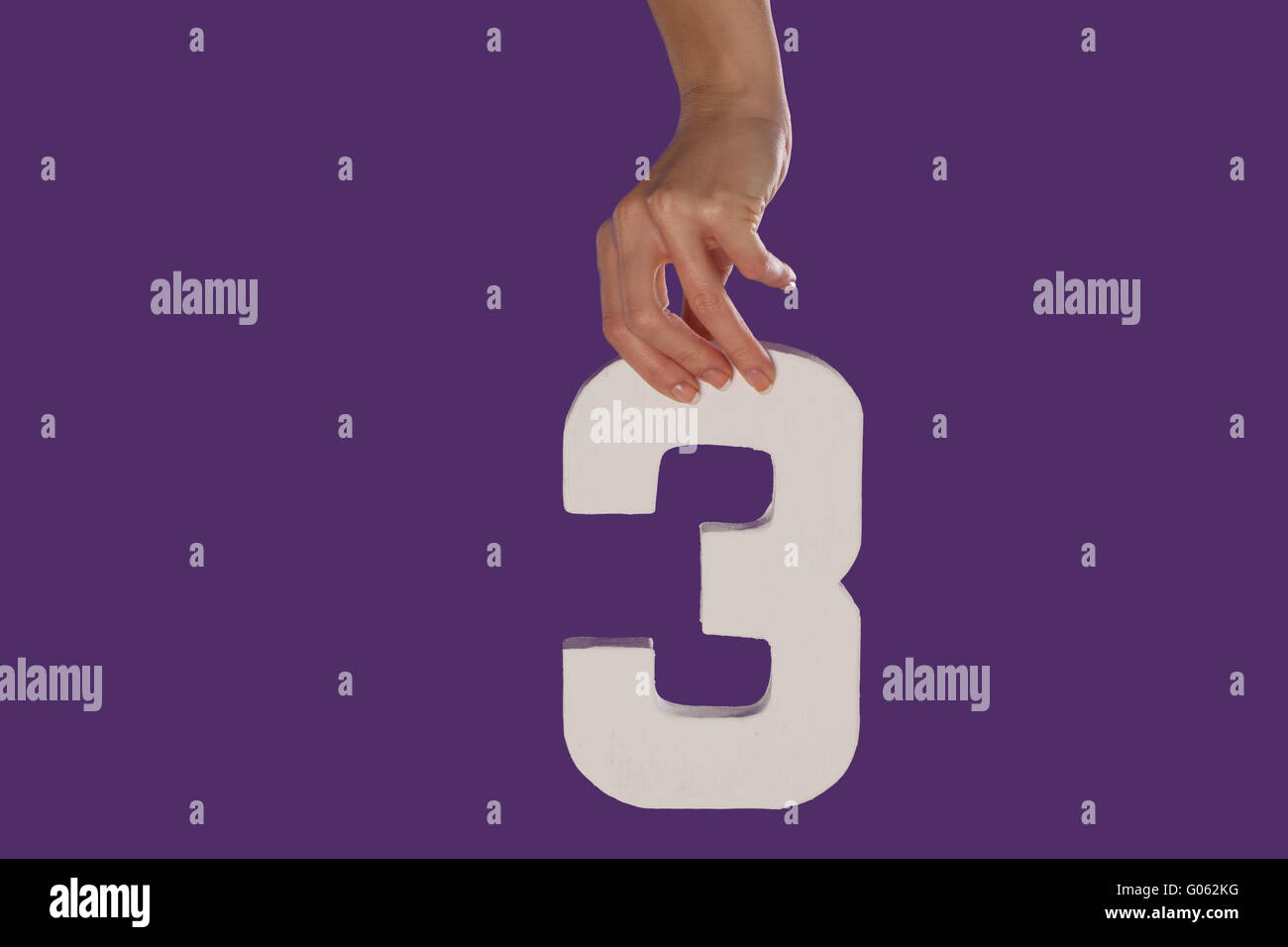 Femmina lato tenendo premuto il numero 3 dalla parte superiore Foto Stock