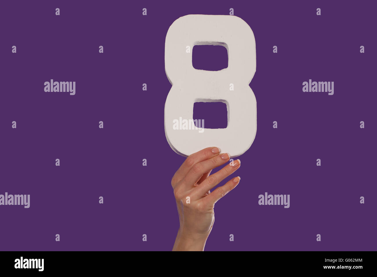 Femmina lato tenendo premuto il numero 8 dalla parte superiore Foto Stock