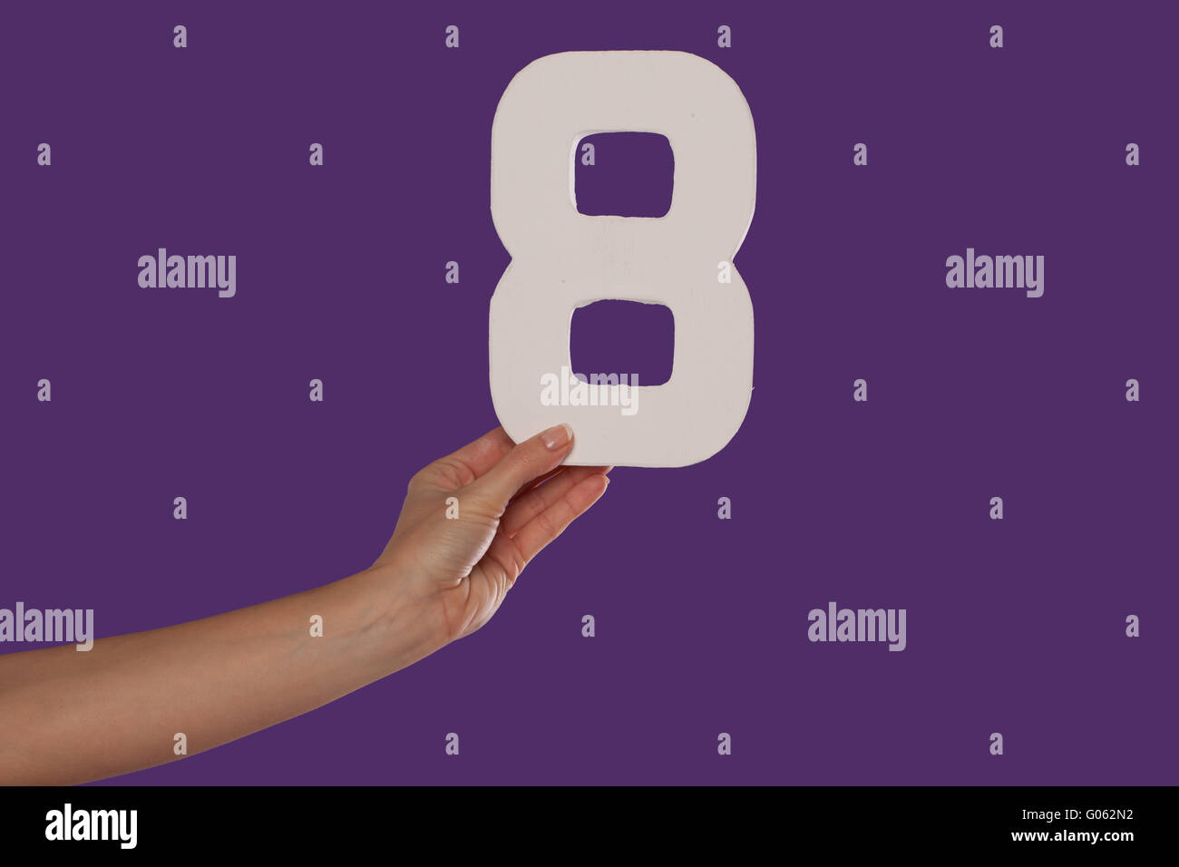 Femmina tenuta a mano fino al numero 8 da sinistra Foto Stock
