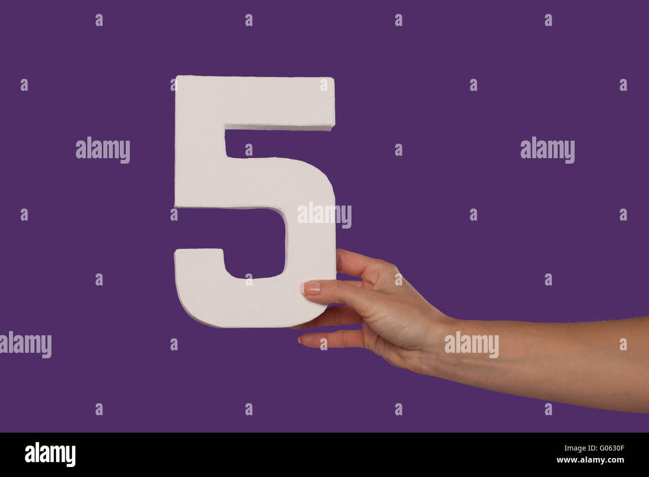 Femmina tenuta a mano fino al numero 5 da destra Foto Stock