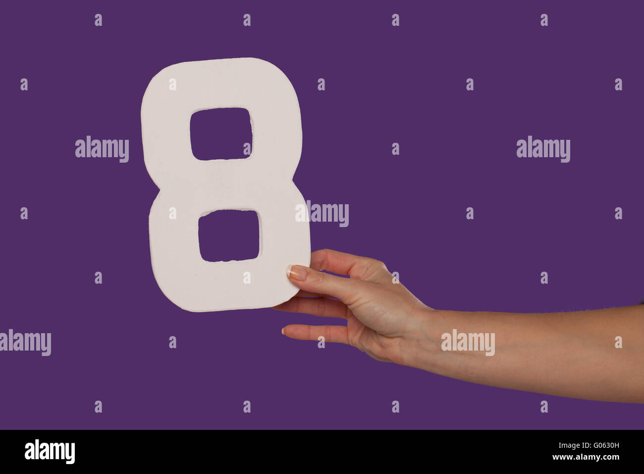Femmina tenuta a mano fino al numero 8 da destra Foto Stock