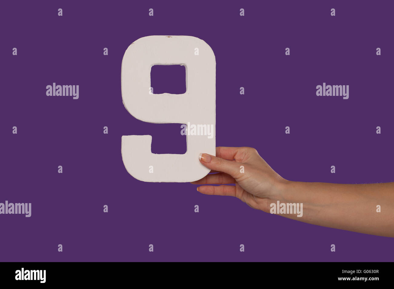 Femmina tenuta a mano fino al numero 9 da destra Foto Stock