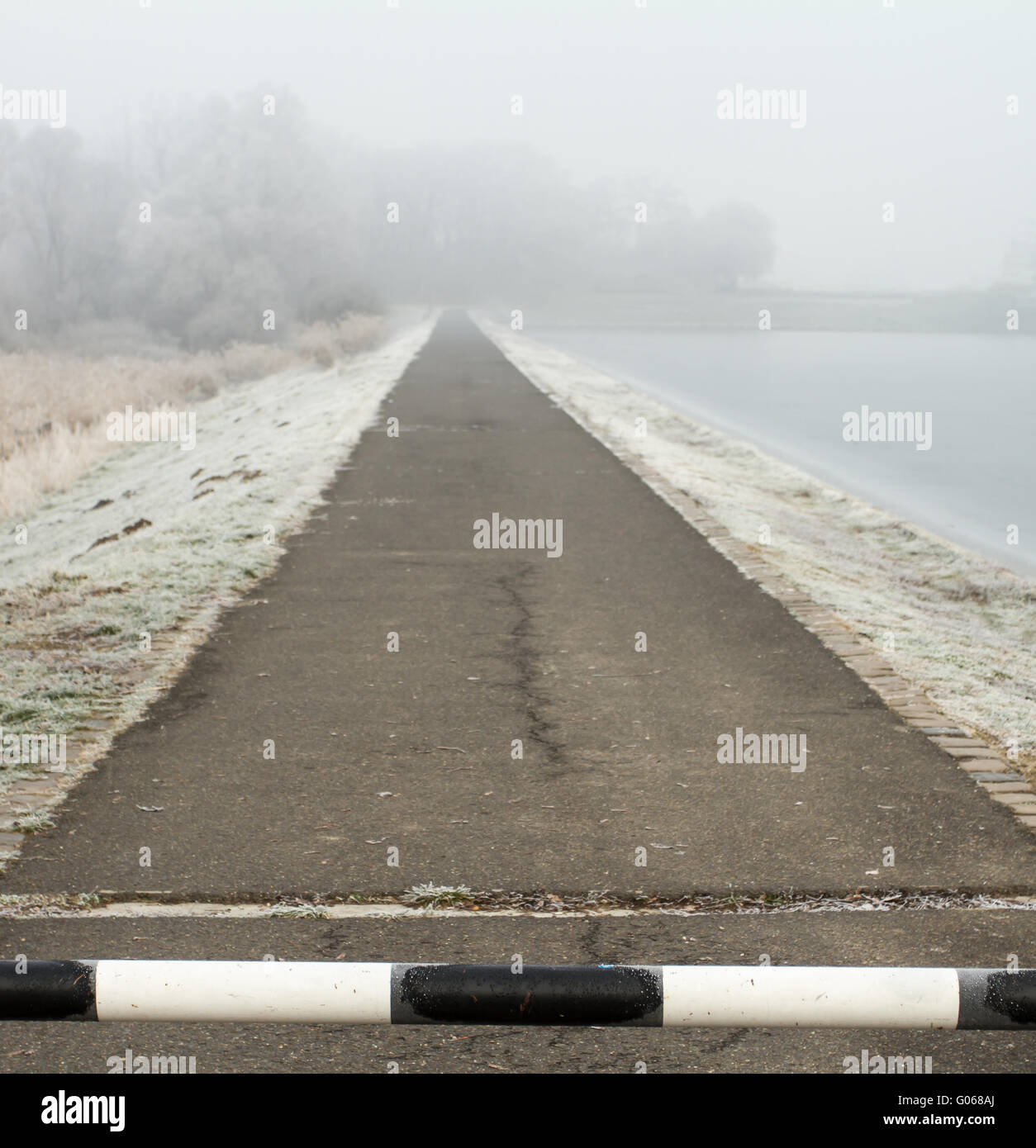 Strada da lontano con barriera al congelamento hoarfrosted paesaggio Foto Stock