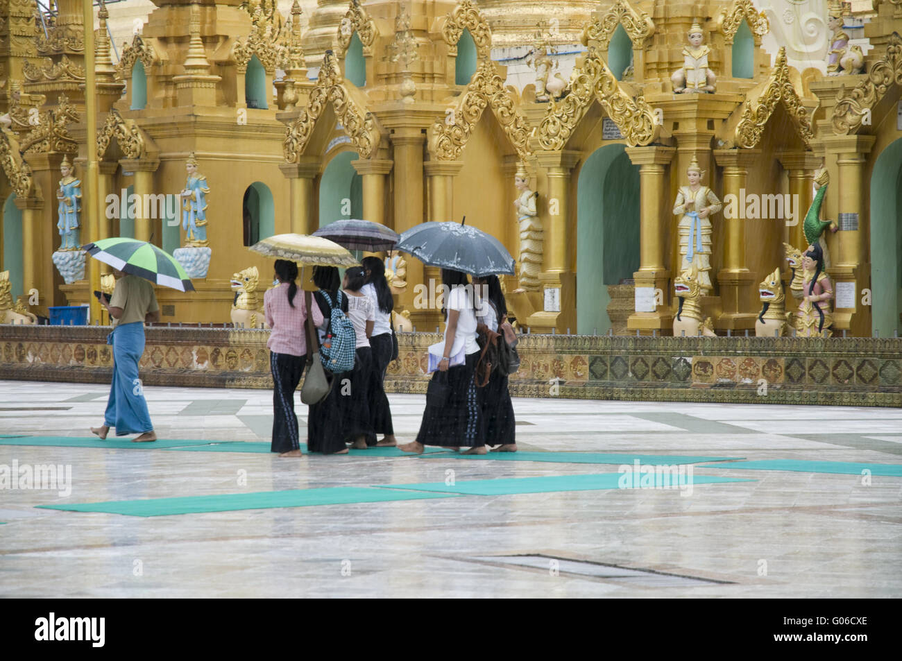 Persone sotto la pioggia alla Shwedagon, Yangon, Birmania Foto Stock