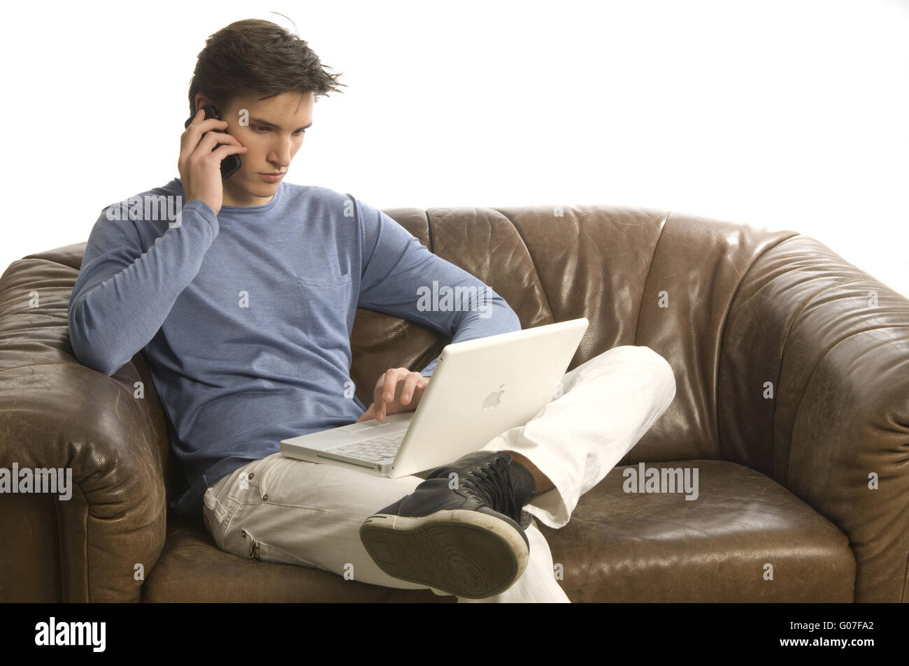 Uomo con il telefono cellulare e il computer portatile Foto Stock