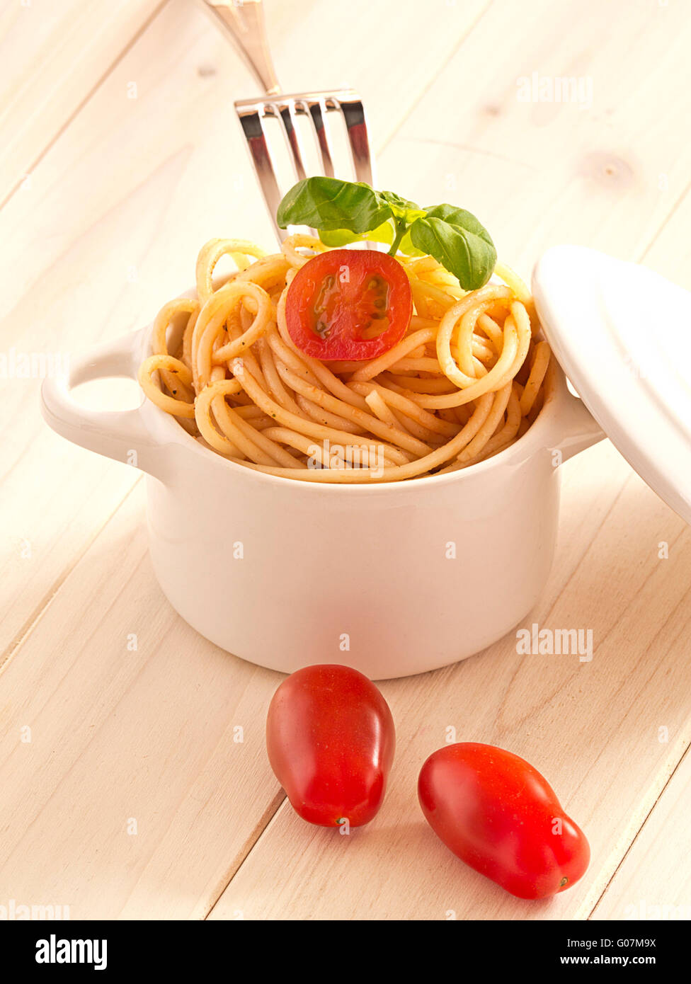 Spaghetti con pomodori e basilico in un earthenwar Foto Stock