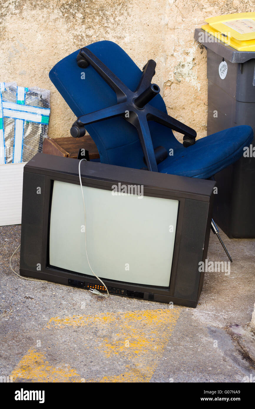 Old Junk sdraiato sul pavimento accanto al bidone della spazzatura Foto Stock