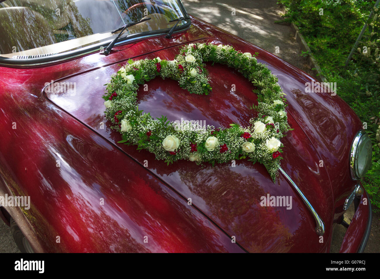 Mazzo di fiori a forma di cuore sulla auto oldtimer Foto Stock