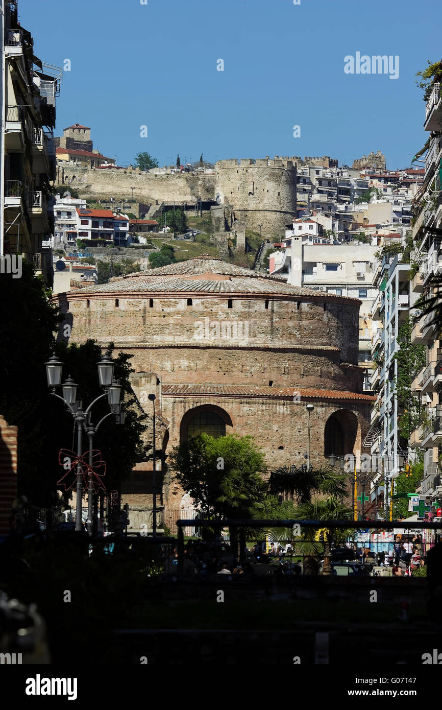 Rotunda monumento medievale circondata da edifici del centro e torre di Trigonio pareti in Ano Poli (città alta) lontano. Tessalonica Foto Stock