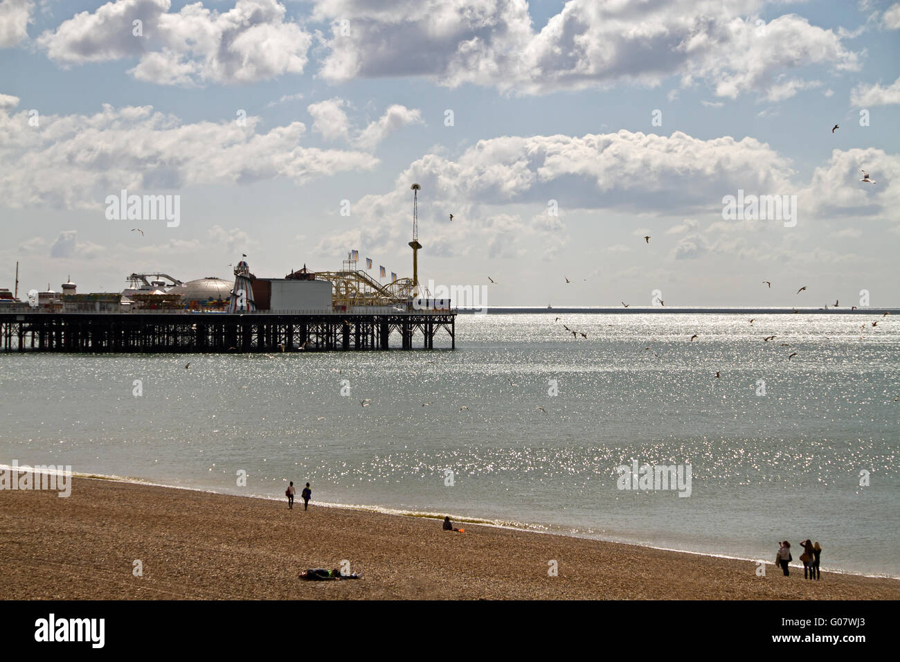 La luce del sole sul mare scintillante e nuvole con molo di Brighton Foto Stock