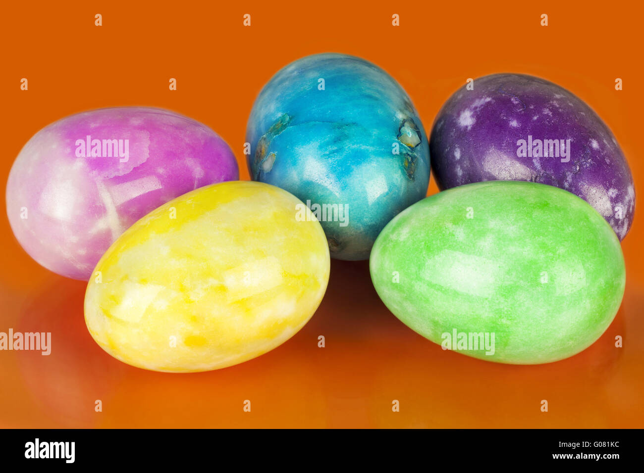 Uova di Pasqua in diversi colori su un arancione indietro Foto Stock