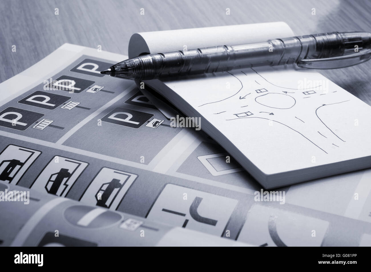 Blocco note, libro delle regole di traffico e penna su una scrivania. Studiare e preparare per il pilotaggio di esame di prova Foto Stock